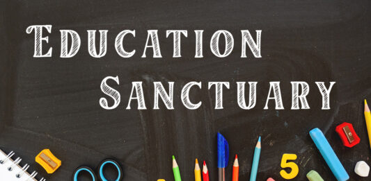 Picture shows a blackboard with the words Education Sanctuary